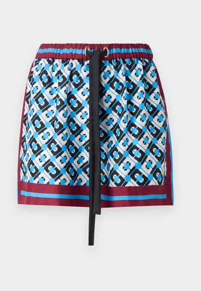 Jupe courte avec un motif géométrique bleu et noir, taille élastique avec cordon de serrage, et bord bordeaux en bas.