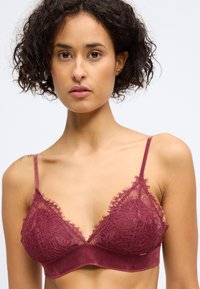 Bralette de encaje burdeos con delicados volantes, banda de tela suave y tirantes ajustables. Presenta intrincados patrones florales en las copas.