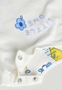 Valkoinen puuvillainen body, jossa on siniset painetut tekstit "LITTLE ONE" ja kukkakuva, hopeiset nepparit alaosassa sekä värikäs vuori.