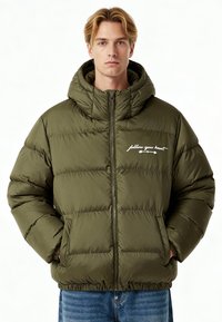 Giacca imbottita verde oliva con collo alto e cappuccio. Presenta una zip frontale, due tasche laterali e testo stampato bianco sul petto.