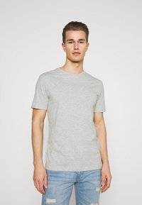 Grå bomull T-skjorte med rund hals og korte ermer. Glatt tekstur, lys melange mønster, kombinert med slitte lyseblå jeans.