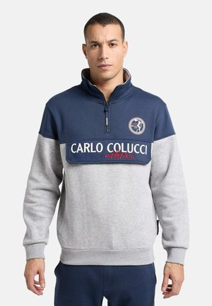 Half-zip sweatshirt met een marineblauwe bovenkant en een grijze onderzijde, voorzien van een geborduurd logo en de opvallende tekst "CARLO COLUCCI atletico" over de borst.