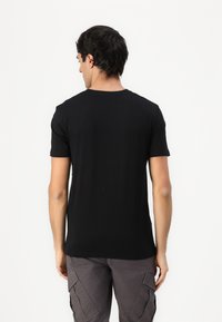 Sort bomuldskorteærmede t-shirt med et klassisk crew neck-design. Glat tekstur, tætsiddende pasform og bagside uden tryk eller logoer.