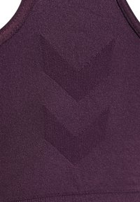 Fioletowy sportowy top o gładkiej fakturze z wyraźnym wzorem, na którym znajdują się dwa strzałki skierowane w dół w nieco jaśniejszym odcieniu.