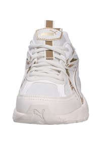 Sneaker bianco con accenti dorati, in rete testurizzata e materiali sintetici, dotato di lacci, linguetta imbottita e una suola in gomma spessa.