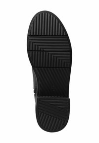 Suela de zapato de goma negra con una superficie texturizada. Presenta ranuras horizontales y diagonales para una mejor tracción. Diseño de puntera redondeada.