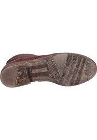 Suela de zapato de cuero marrón con patrones de agarre texturizados, impresión de logo y marcas de desgaste visibles. Presenta una forma redondeada y un diseño de tacón plano.