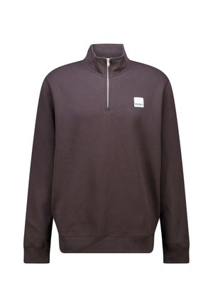 Sudadera marrón con media cremallera y un alto cuello, puños de canalé y un pequeño parche blanco con logo en el pecho. Fabricada con material suave y ligero.