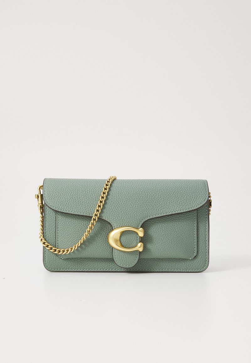 Petit sac à main en cuir vert clair avec bandoulière chaîne dorée et grande boucle dorée en forme de C sur le rabat avant.