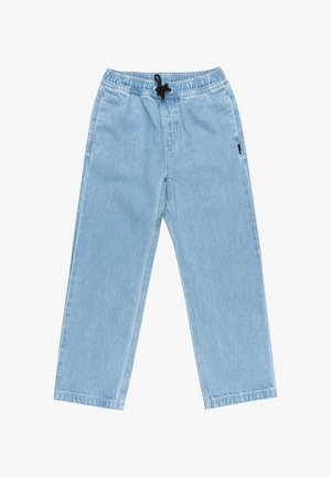 Person iført en blå Element-logo t-shirt, løse lyseblå jeans og sorte sneakers med hvide såler, stående mod en ensfarvet baggrund.