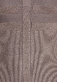 Haut tricoté avec un motif côtelé texturé dans une couleur marron douce, comprenant des fils métalliques subtils et une bande verticale centrale.