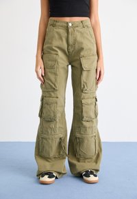 Olijfgroene cargopants met meerdere grote zakken, ruime pijpen en een knoopsluiting in de taille. Gemaakt van gestructureerde katoenen stof.