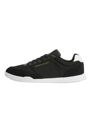 Czarny niski sneaker z białą podeszwą, cholewką z siateczki i zamszu oraz logo "Tommy Hilfiger" po boku w małych złotych literach.