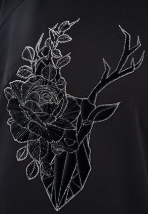 Wyszywana czarna aksamitna głowa jelenia z srebrnymi konturami i kwiatowymi liśćmi na czarnym tle materiału.