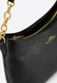 Borsa a mano in pelle nera con superficie texturizzata, hardware dorato e tracolla a catena. Presenta una chiusura con zip superiore e dettagli con logo in rilievo.