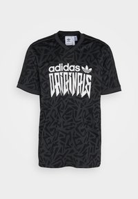 Černý krátký rukávový dres s grafickým vzorem, bílý text "adidas" a "ORIGINALS" a výstřihem do V. Materiál se zdá být hladký.