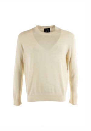 Kermanvärinen pitkähihainen pyöreäkauluksinen neule, jossa on resorit hihansuissa ja helmassa sekä pieni kirjailtu logo rinnassa.