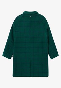 Grønn ullfrakk med et mørkeblåk rutemønster, kragehals, drop shoulders og knappelukking på mansjettene, med en rett skjæring.