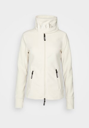 Hvid fleecejakke med høj krave præget med "Bench", fuld lynlås foran og to lynlåslommer i siden med sorte trækkedimser.