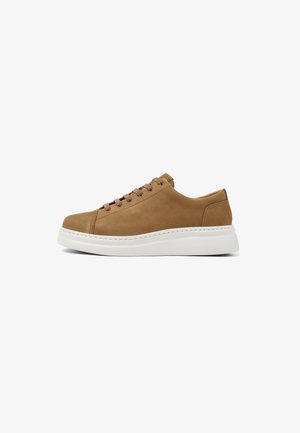 Tan suede sneaker with a white rubber sole, featuring six matching eyelets for laces and a rounded toe design.