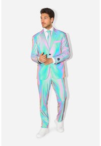 Iridescent pak in pastelkleuren roze en groen, met een getailleerde pasvorm, blazer met zak, bijpassende broek en witte sneakers.