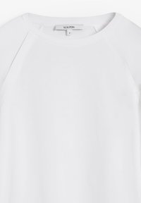 Sudadera blanca de cuello redondo con mangas raglán y una pequeña etiqueta de la marca Scalpers en el cuello, talla pequeña.