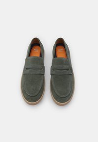 Rohelised sametist loaferrid, millel on libisemise disain; ülaosas lai rihm ja kummist tald. Sisesole on oranž.