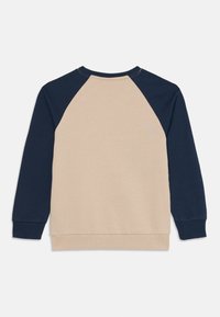 Sweatshirt bege com mangas raglan em azul marinho. Apresenta punhos e barra canelados, textura suave e design descontraído de gola redonda.