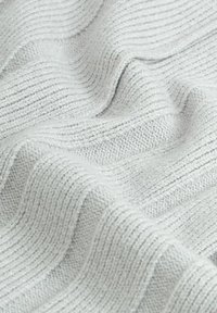 Világosszürke bordázott textil, puha tapintással, jellegzetes vízszintes vonalakkal és finom vastagságváltozásokkal az egész felületen.