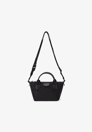 Small black nylon handbag with dual top handles and adjustable shoulder strap, featuring a front logo patch.