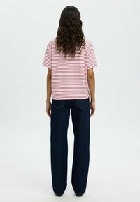 Striped red and white short-sleeve t-shirt, relaxed fit, paired with dark blue wide-leg jeans. Smooth texture, clean silhouette.