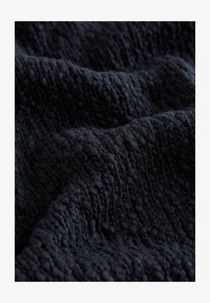 Tessuto strutturato blu scuro con un motivo a maglia, caratterizzato da onde e sporgenze, che sottolineano morbidezza e spessore.