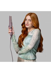 En straightener for hår i lavendel med slankt design, teksturert grep og en tilkoblet strømkabel, holdt av en person i en marmorert mint-top.