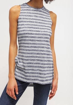 Top sin mangas con rayas grises y blancas, de tejido acanalado, combinado con jeans azul oscuro, mostrado en un modelo desde el cuello hasta las caderas sobre un fondo liso.