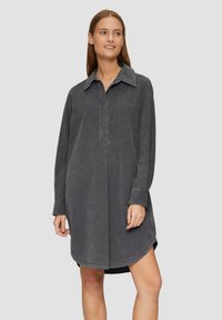 Langärmliges Hemdkleid aus dunkelgrauer Baumwolle, mit einem kragenlosen Ausschnitt, Knopfleiste und geschwungener Saumlinie. Glattes, strukturiertes Material.