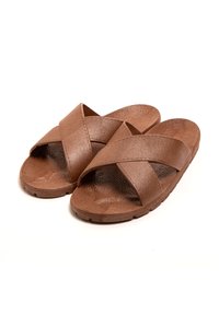 Braune Rutschen-Sandalen mit überkreuzten, strukturierten Riemen. Hergestellt aus synthetischem Material, mit flacher Sohle und dezentem Strukturmuster.