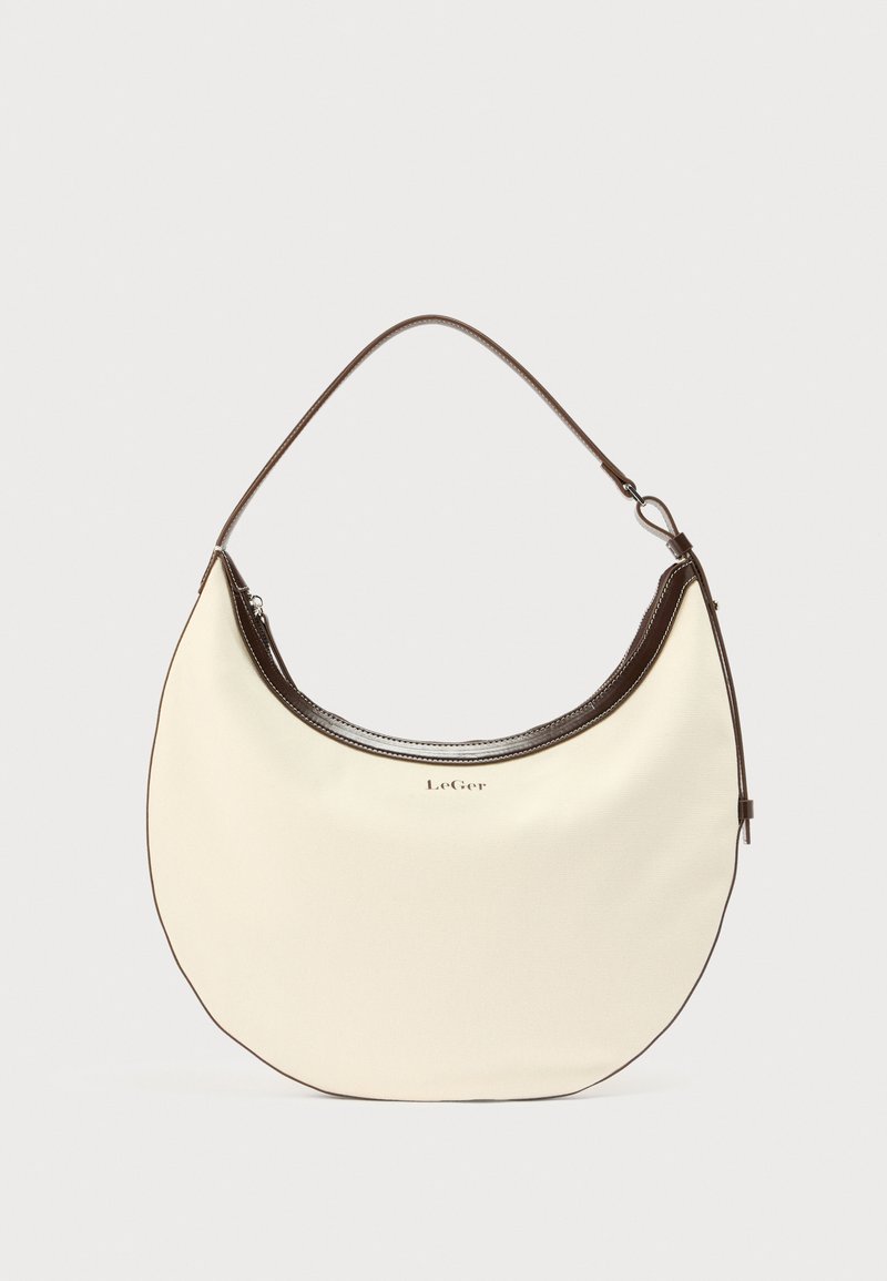 Κρεμ τσάντα ώμου σε σχήμα ημισελήνου με σκούρο καφέ περίγραμμα, μονή λουρίδα και λογότυπο «LeGer» στο κέντρο μπροστά.