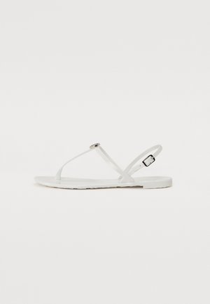 White flat sandals with a minimalist design, featuring thin straps, a small decorative buckle, and a smooth, flat sole.