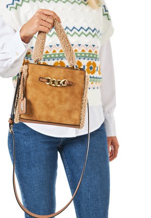 Brown leather handbag with shearling accents, gold chain detail, and a detachable shoulder strap. Square shape, compact design.