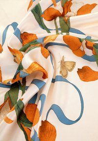 Tessuto satinato con un motivo floreale arancione e verde, caratterizzato da un motivo a nastro blu. È visibile anche una piccola farfalla beige.