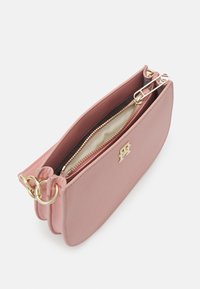 Růžové kožené pouzdro se zlatým zipem, dvěma oddíly a logem. Hladká textura s zaoblenými hranami a kovovými detaily.