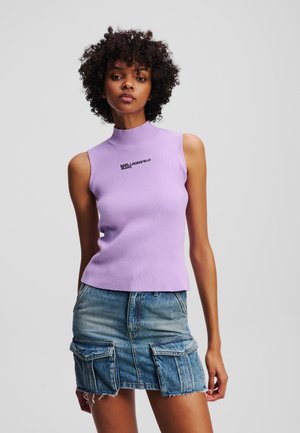 Paarse geribbelde mouwloze top met een hoge hals, met een zwart geborduurd "Karl Lagerfeld Jeans" logo. Gepaard met een blauwe denim minirok.