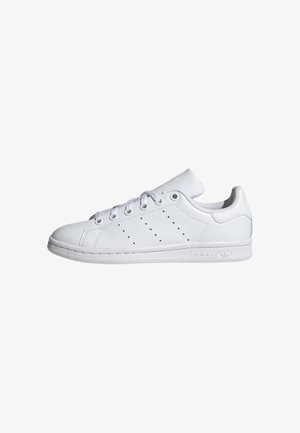 Beli nizki sneaker s usnjenim zgornjim delom, zaobljenim prstom, šestimi luknjami za vezalke, perforiranimi črtami, ravnim gumijastim podplatom in blagovno znamko na peti.