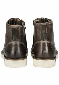Bottes chelsea en cuir marron avec une finition lisse, semelles en caoutchouc de couleur claire, zips latéraux et doublure en textile à carreaux.