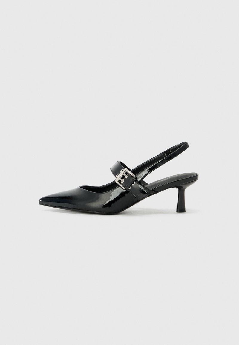 Zapatos de tacón en charol negro con tira al tobillo, punta afilada y un pequeño tacón bloque, que cuentan con un acento de hebilla plateada en la correa.