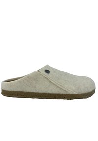 Zuecos de lana en color crema con una textura suave, presentan un diseño cosido y una puntera redonda, combinados con una suela de goma marrón.