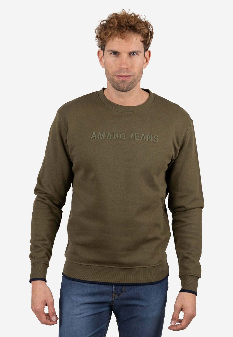 Sudadera verde oliva con cuello redondo acanalado, mangas largas y texto "AMARO JEANS" en un color a juego ligeramente en relieve. Textura suave.