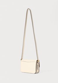 Borsa a tracolla in pelle crema con una texture liscia, caratterizzata da un design flat, una tracolla regolabile e accenti minimalisti in metallo dorato.
