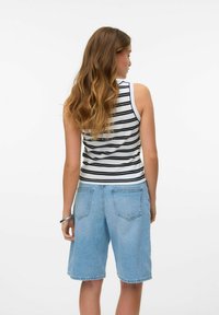 Gestreept tanktop in zwart-wit met een strakke pasvorm, gecombineerd met lichtblauwe denimshorts met een relaxte pasvorm en achterzakken.