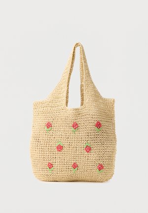 Beige vevd handlenett med korte håndtak, dekorert med små røde og grønne broderte blomster spredd over forsiden.